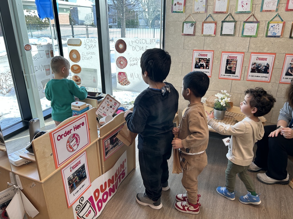 Student working behind the pretend counter at Dunkin while others form a line waiting to be helped.