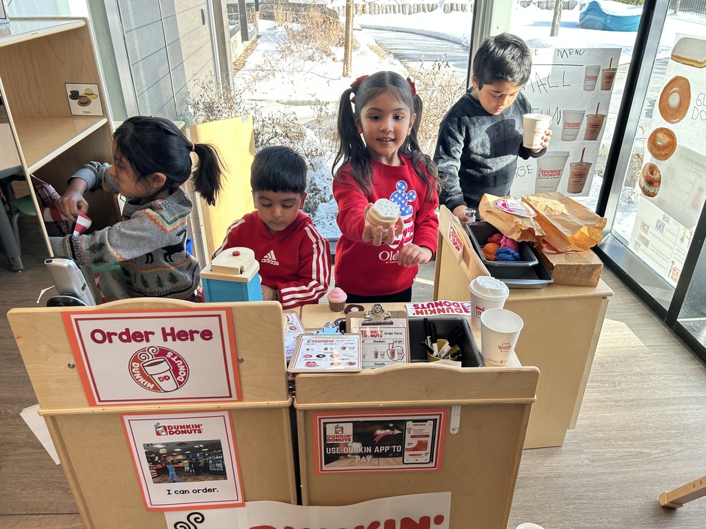 Students are playing in their pretend Dunkin store.