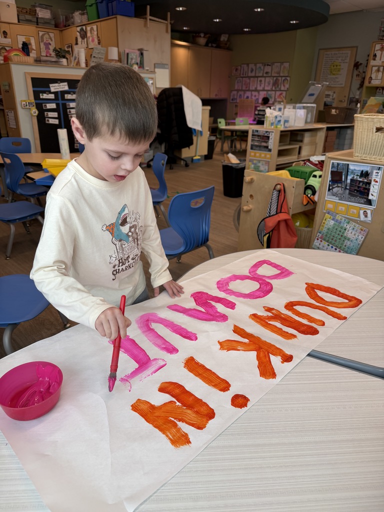 Student painting a Dunkin Donut Sign