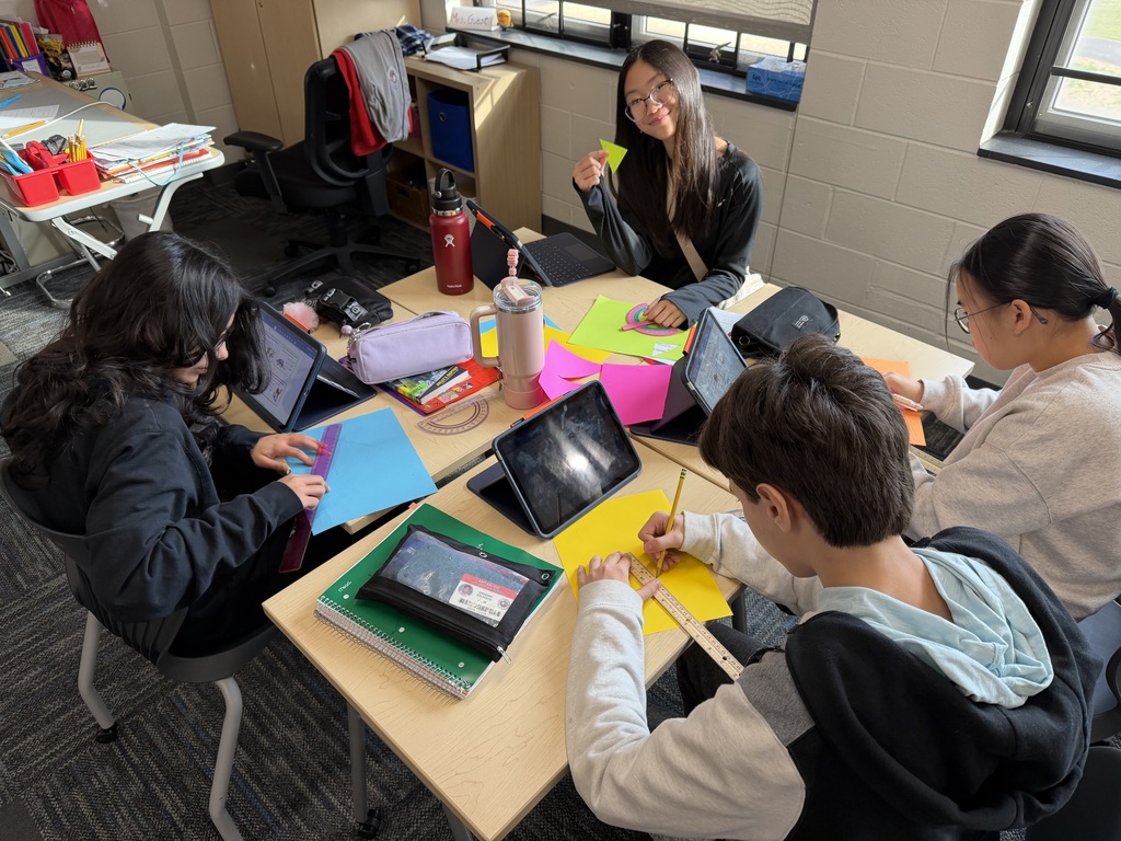 Students working at their desk with shapes, rulers, and ipads.