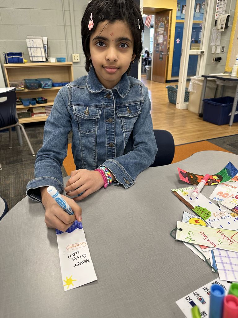 Girl sitting at a desk with a bookmark.