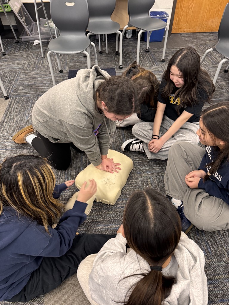 Students giving CPR to a dummy.