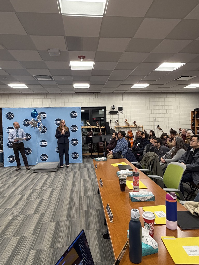 Two district leaders standing in front for a board meeting.