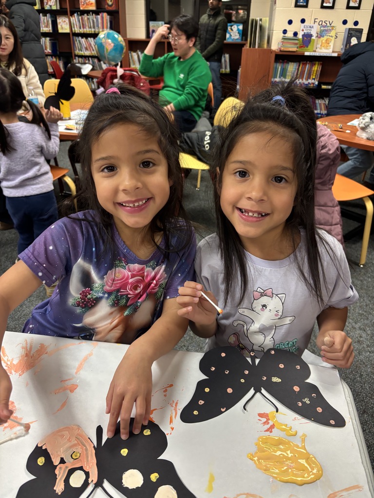 Two girls making a butterfly craft. 
