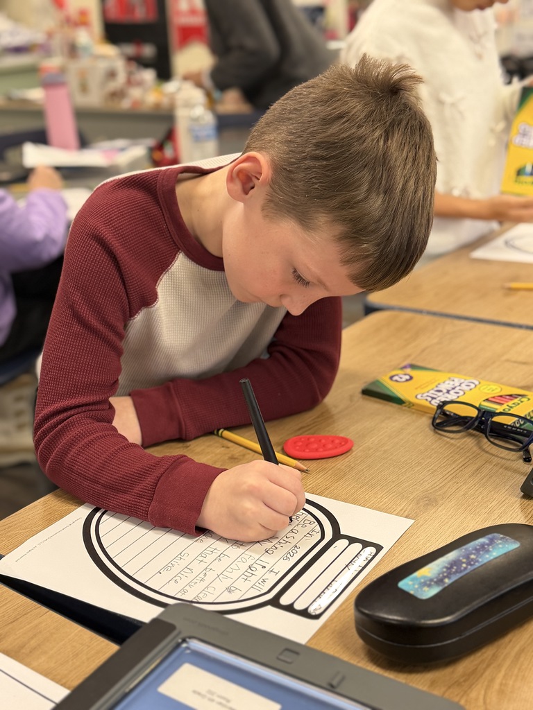 Student sitting at his desk working and writing. 