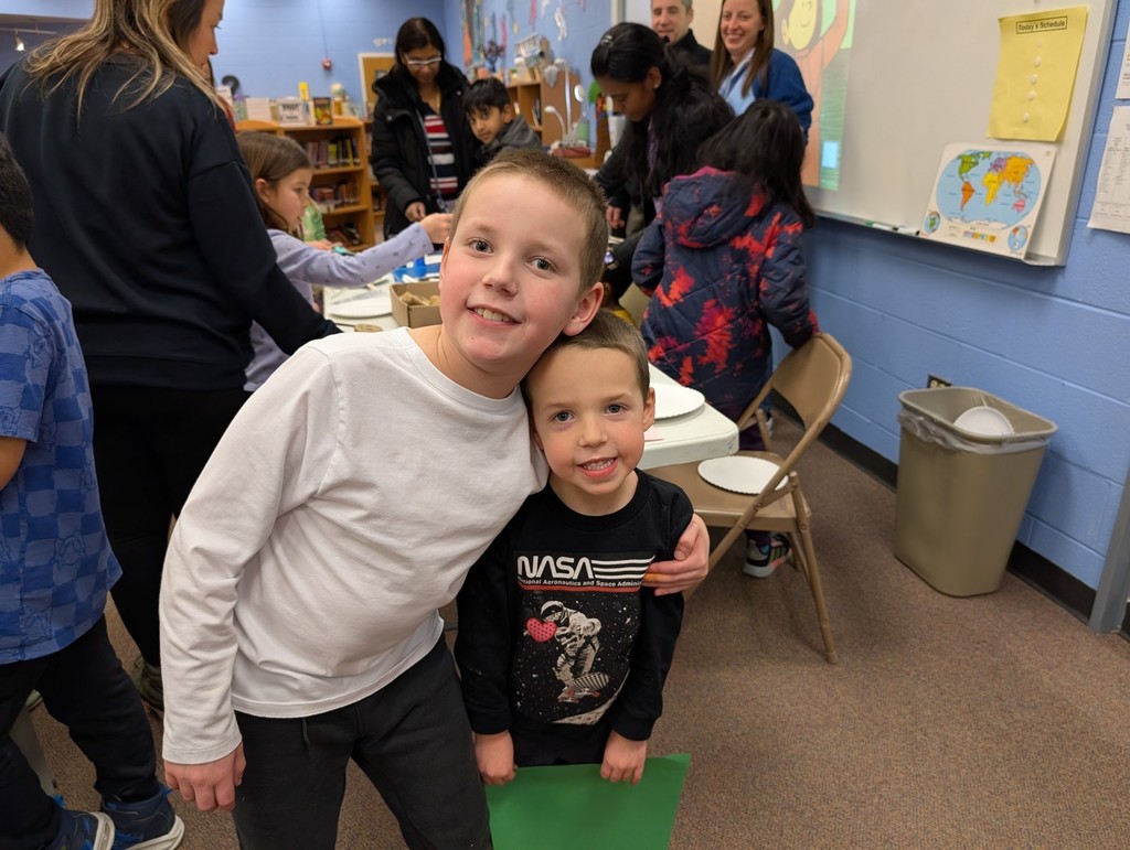 Students holding each other and smiling. 