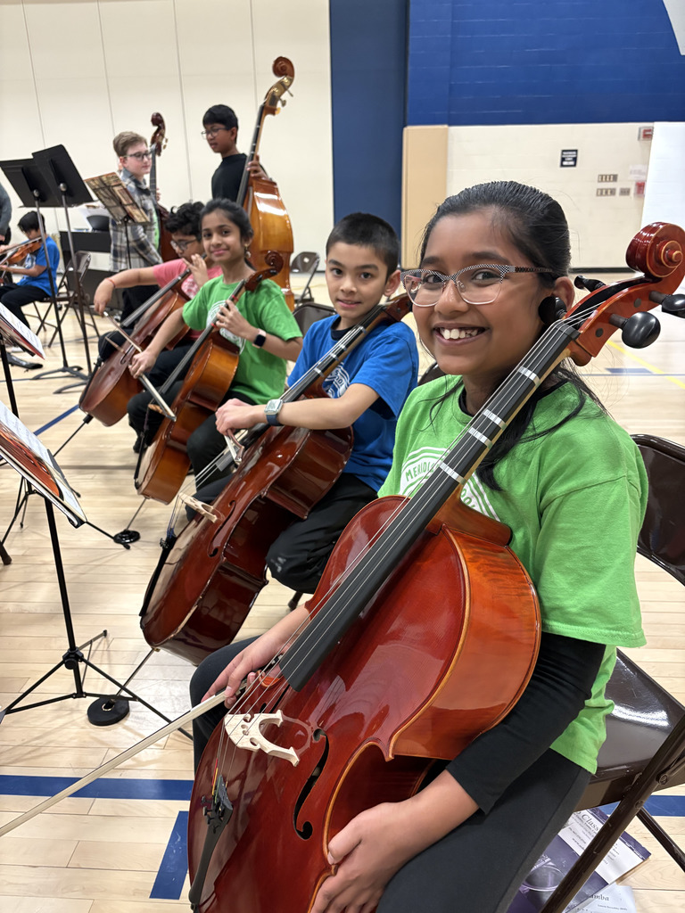 4 students smiling at the camera holding their instruments. 