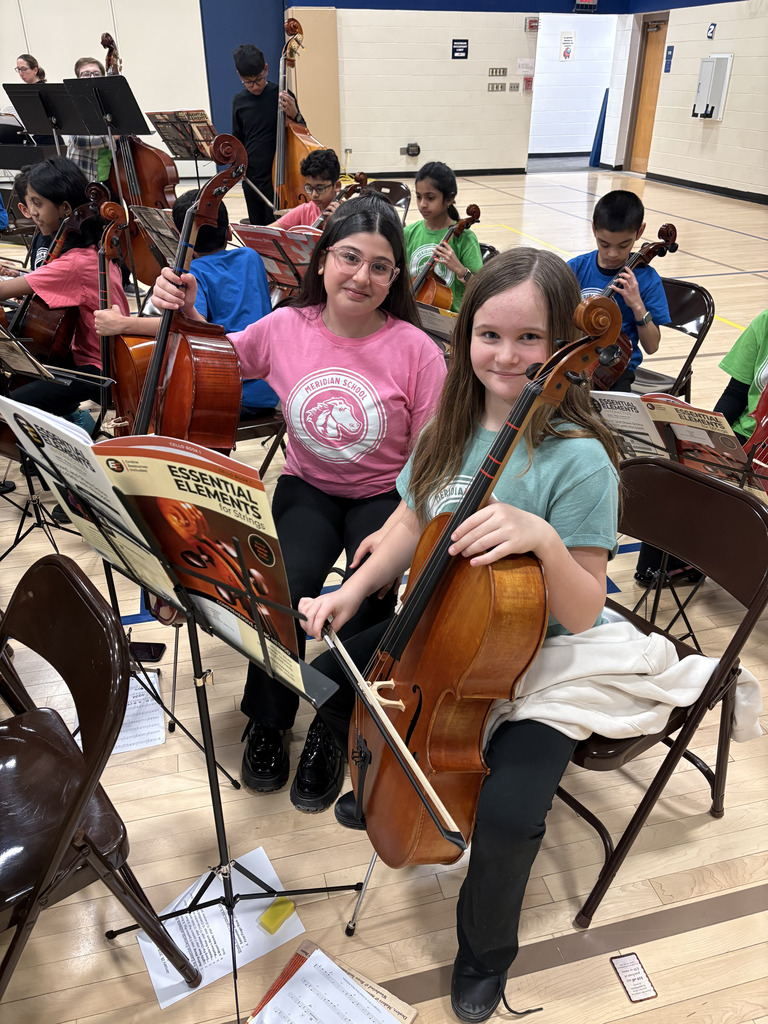 Two girls holding a bass.