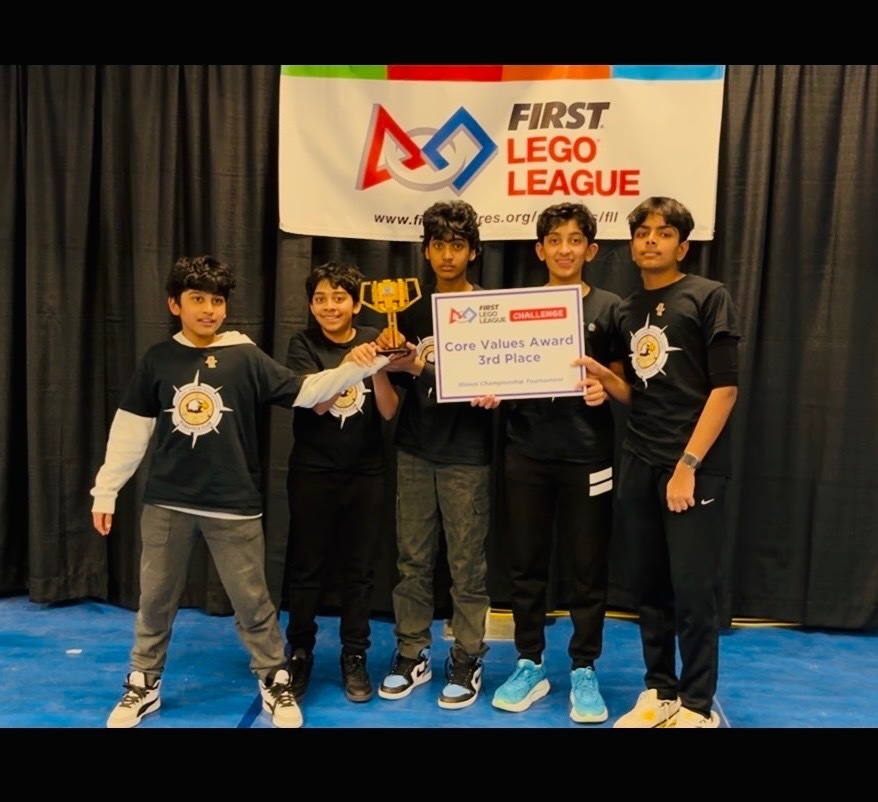 Robotics team standing with a sign and trophy.