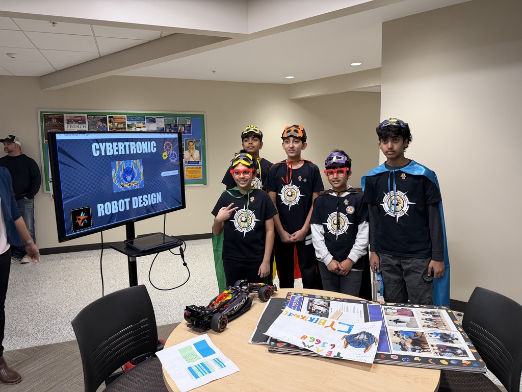 Robotics team standing as a group with masks and capes.