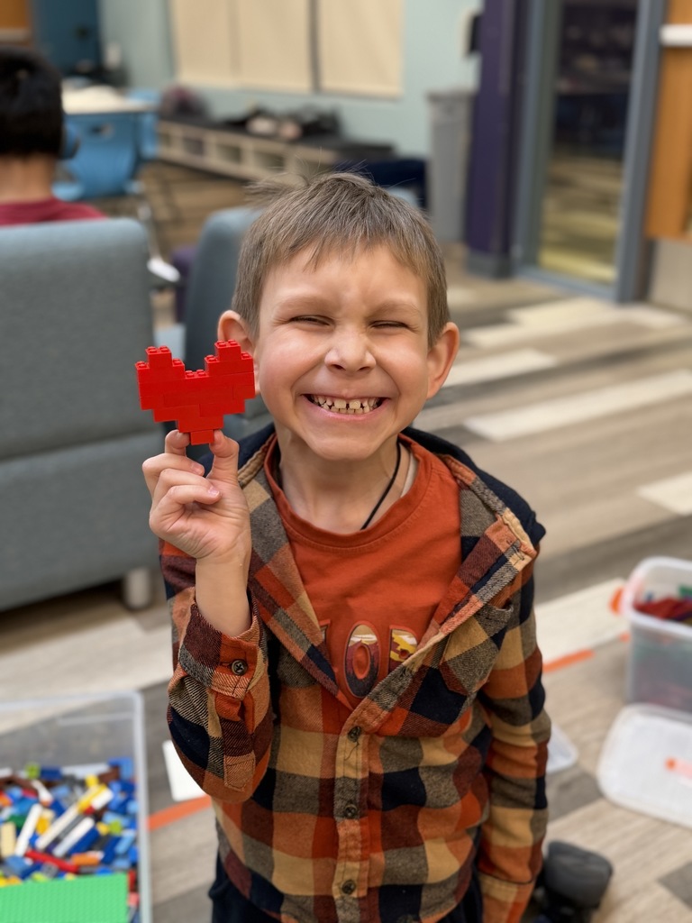 Student holding a heart shaped Lego.