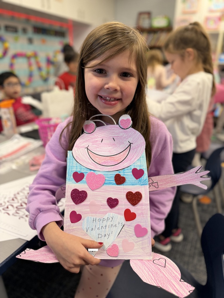 One girl holding up her Valentine frog bag.