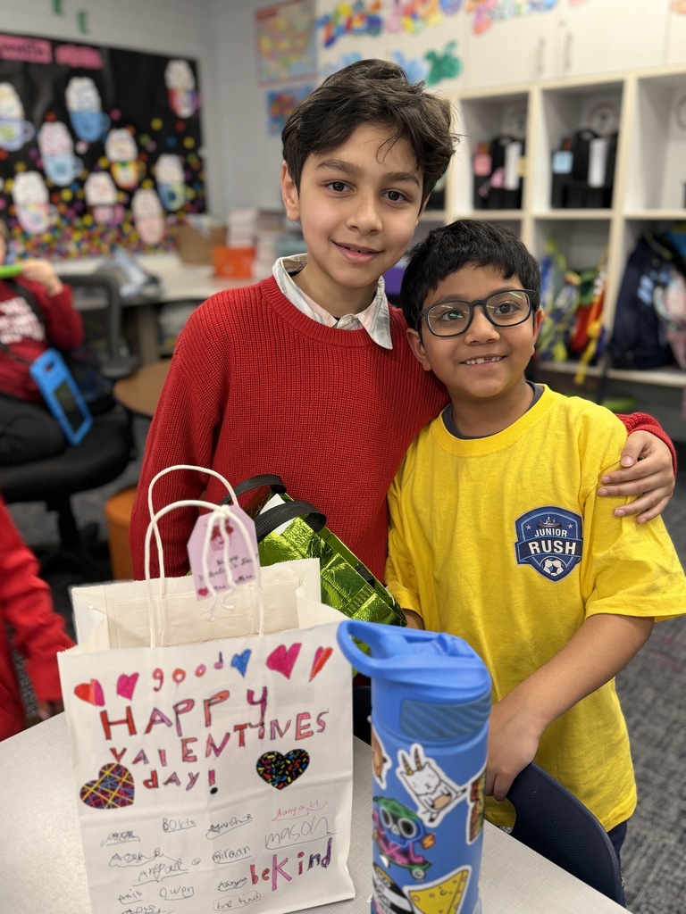 Students standing with one another and passing out Valentines.