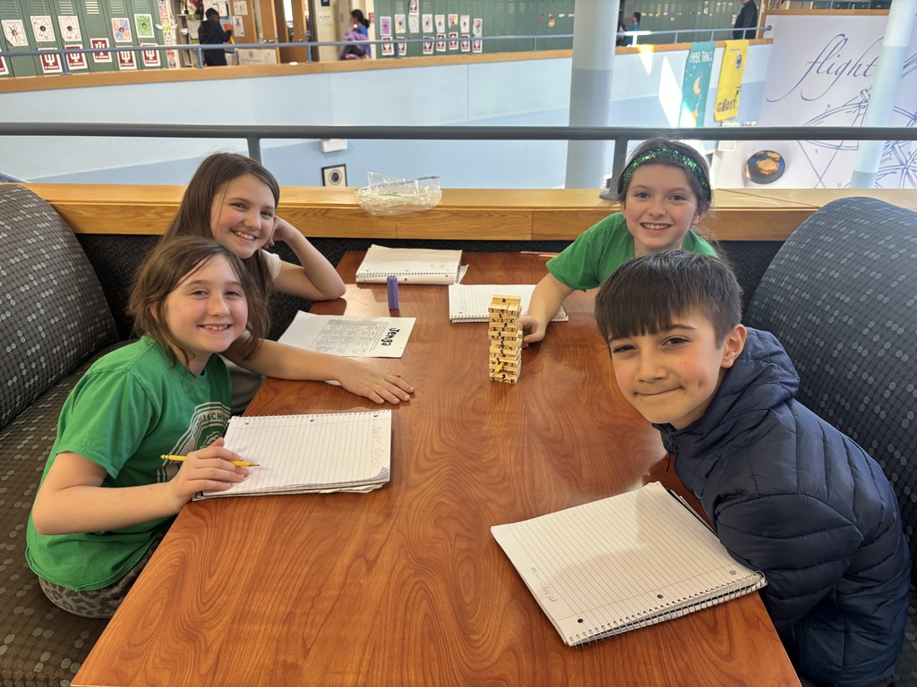 Students sitting at a table with the game of Jenga.