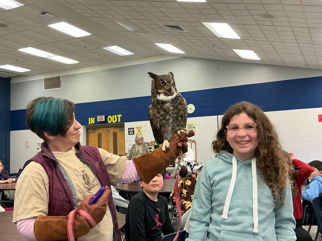 Owl handler holding owl near a student. 