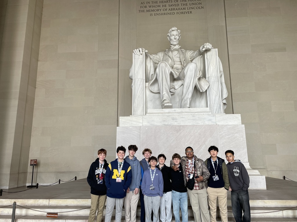 A large group of students standing in front of the Lincoln monument. 