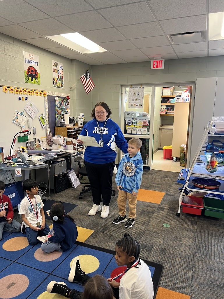 Mrs. Dion awards a student with a kindness award.