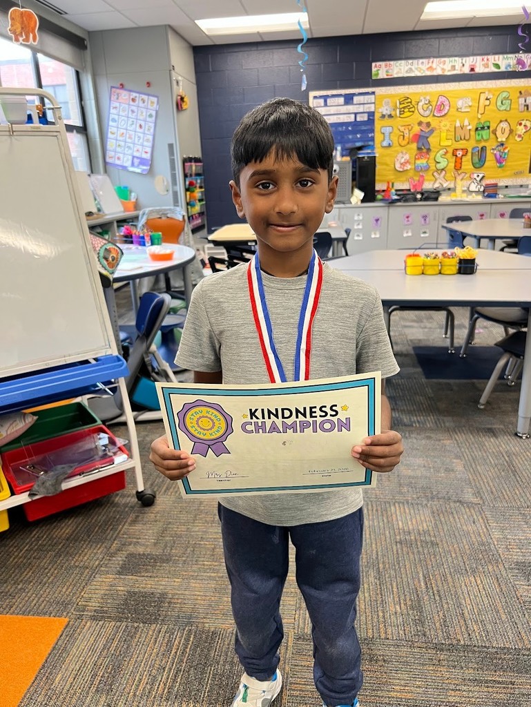Student is holding a kindness certificate. 