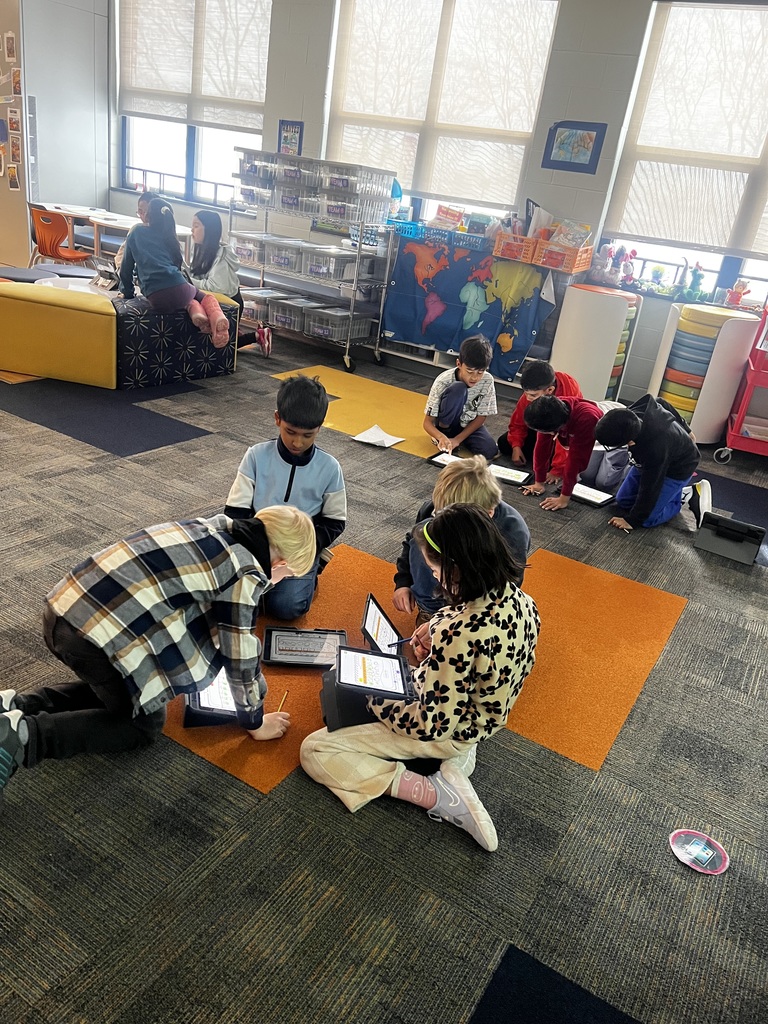 Students working in groups on ipads.