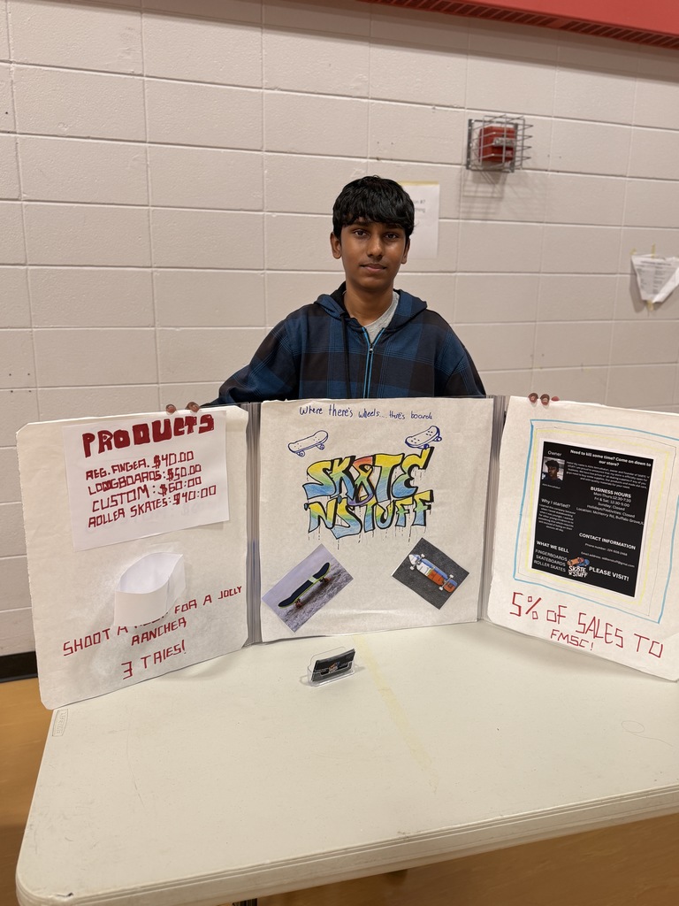 Boy standing behind his work sitting on a table at a fair.