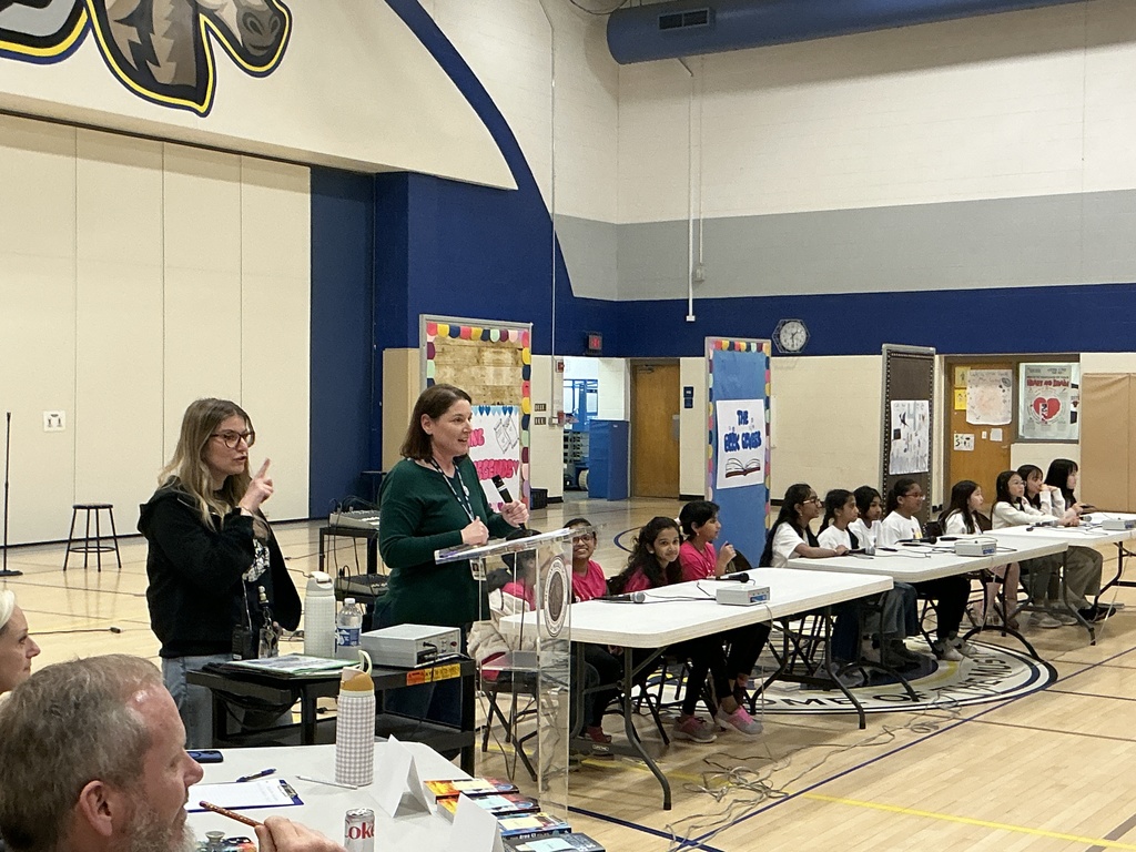 2 teachers talking to the school, while teams wait to start the contest.