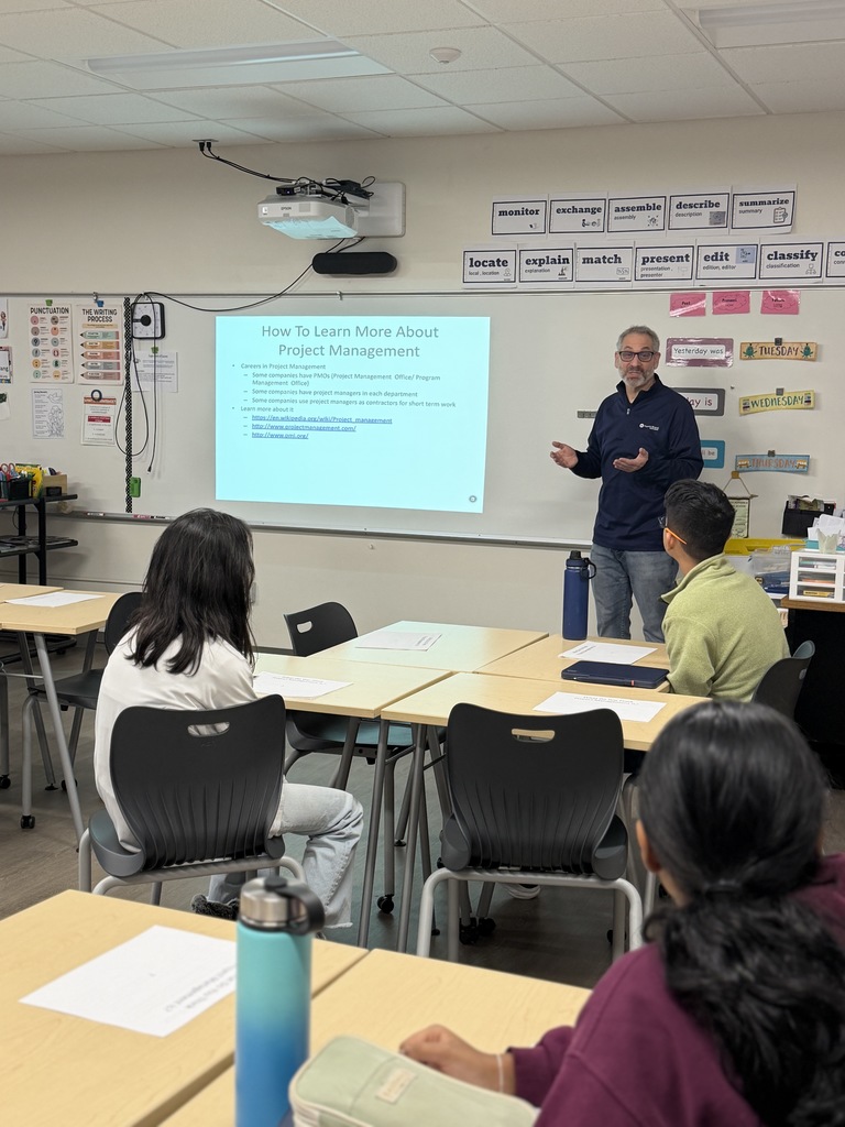 Presenter talking to a group of students about project management.