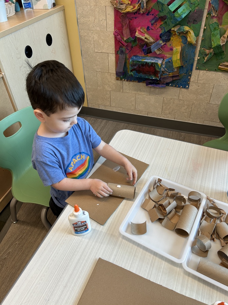 Boy using glue and cardboard to make his art.