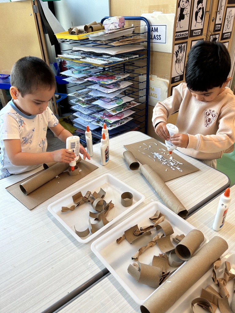 Two boys using glue with their projects.