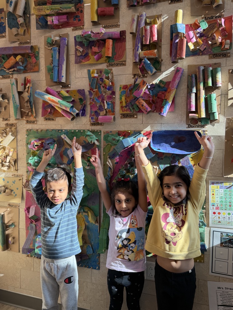 STUdents pointing to recycled art.