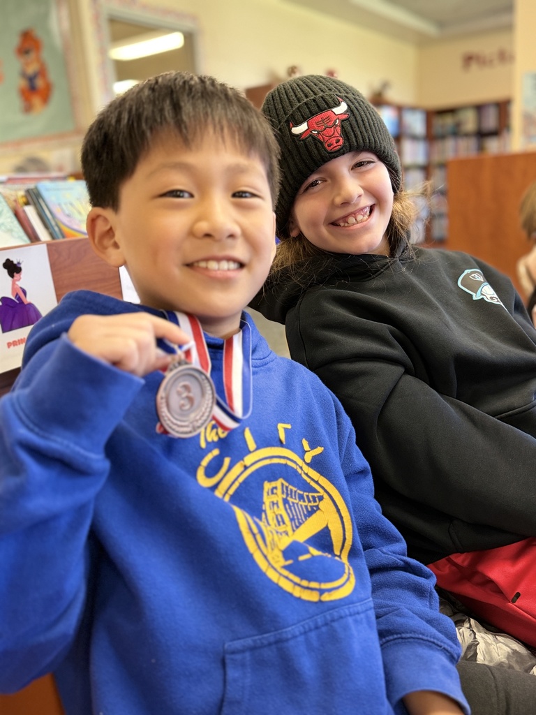 Two boys smiling with a medal.