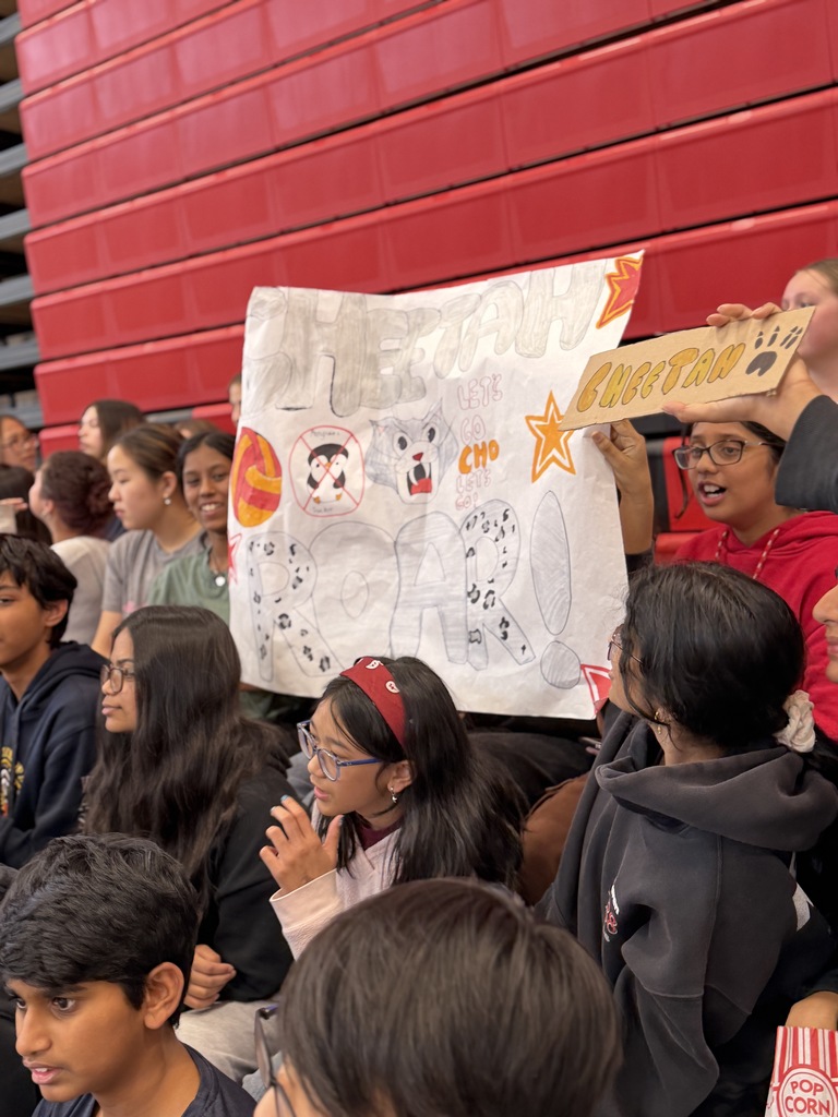 Students holding a sign in the bleachers.