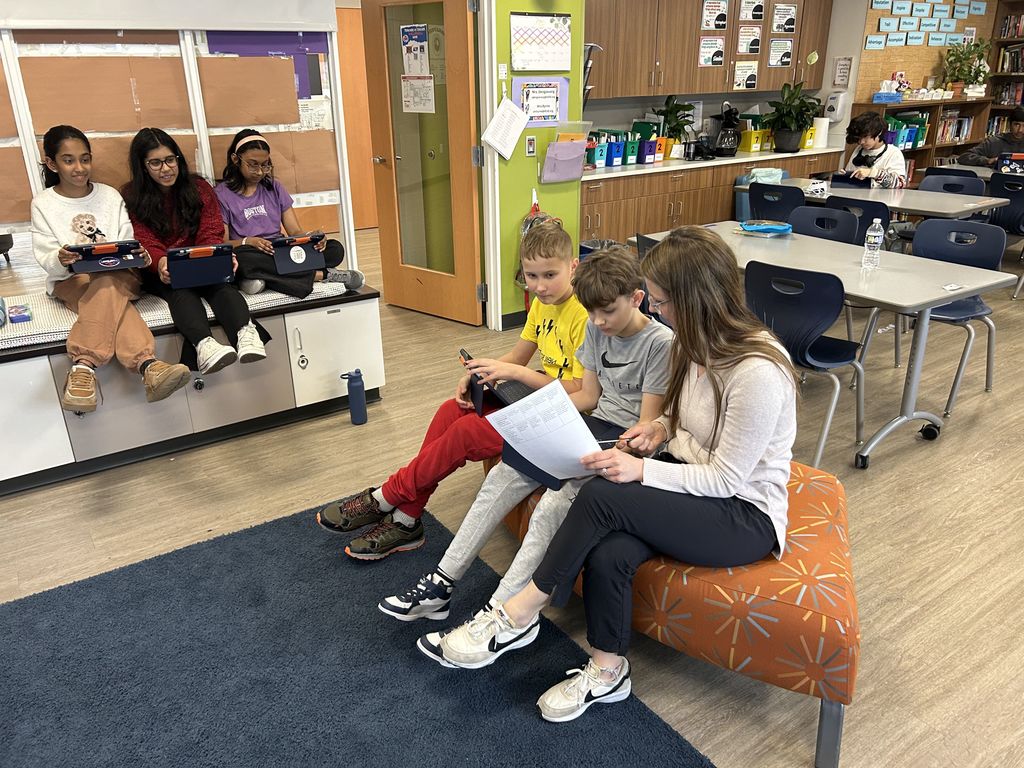 Students sitting with ipads and papers.