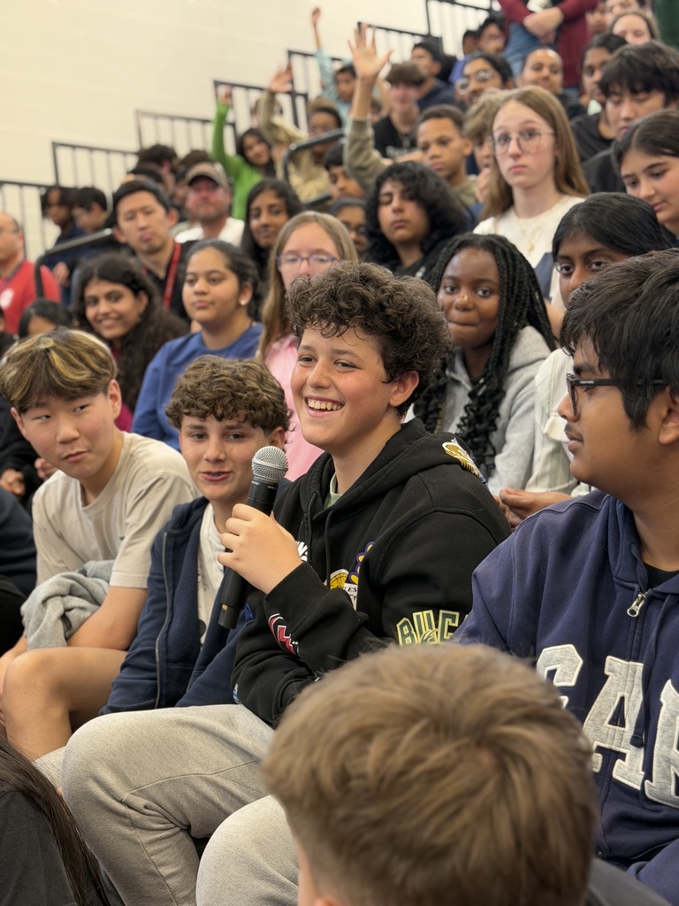 STudent holding a microphone asking a question.