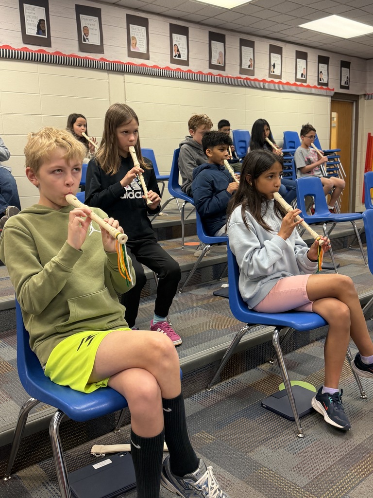 Students playing the recorder while sitting. 