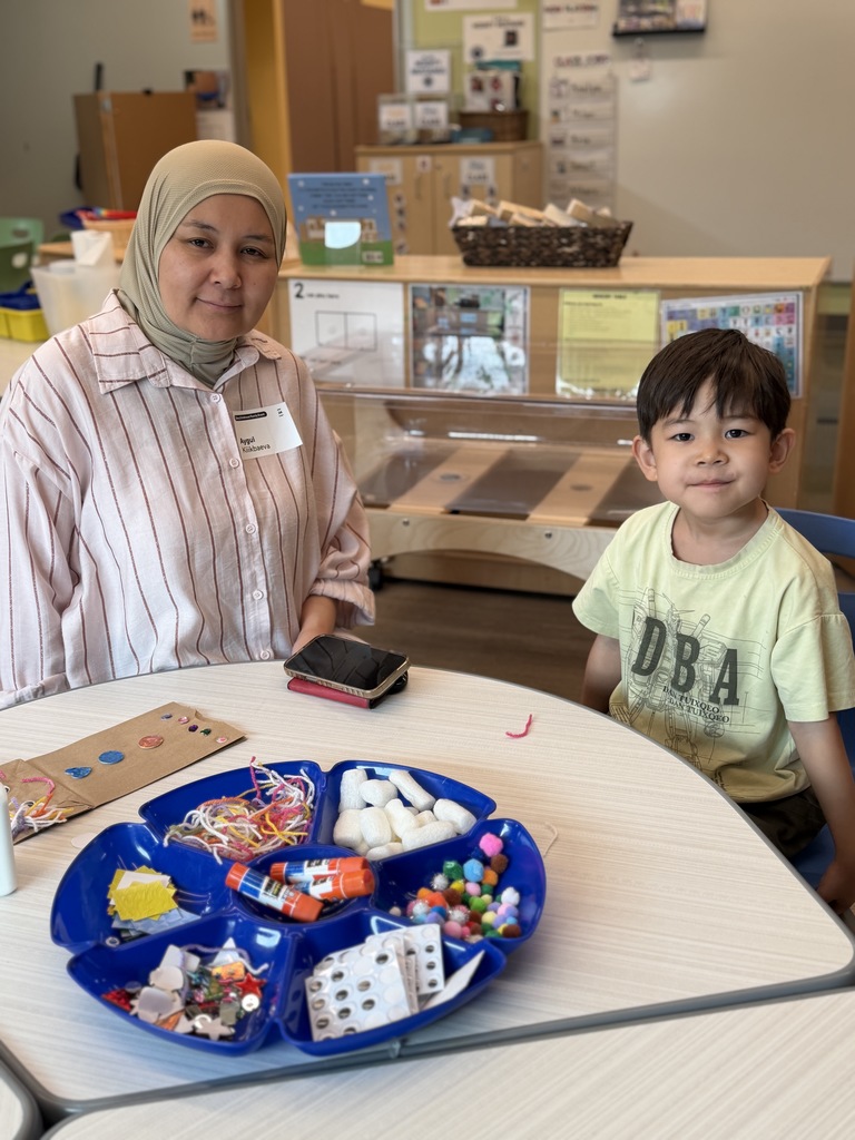 Mom and son sitting together at a table with craft suppllies.