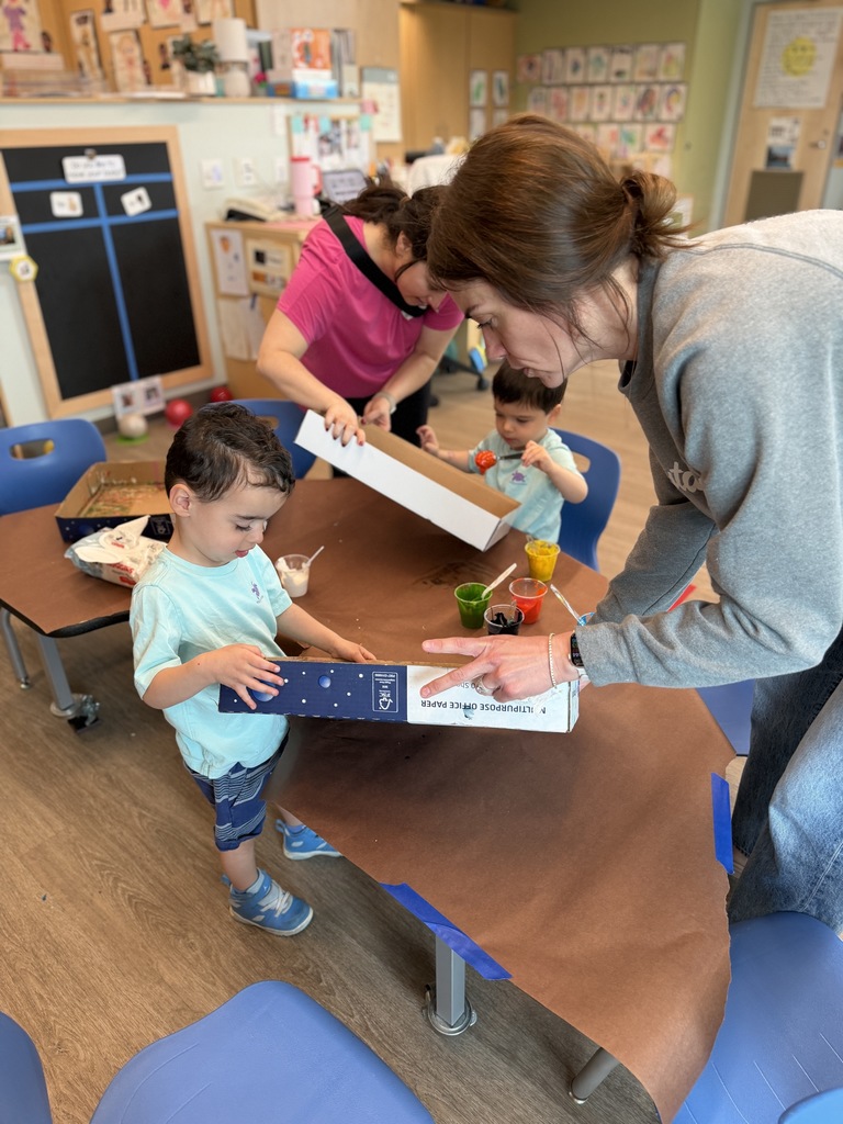 Teacher helping student with marble paint art.