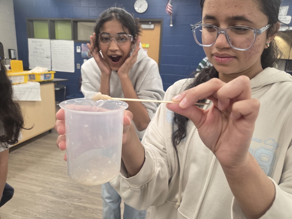 Students holding a q-tip with goo on the tip.