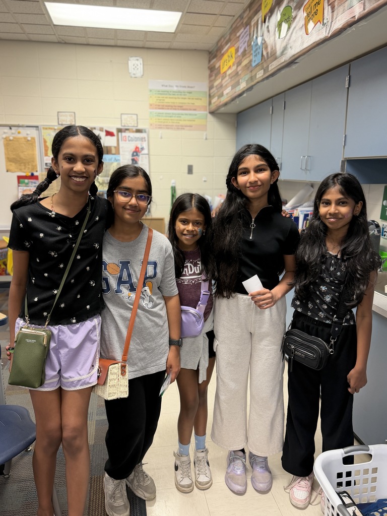 Group of 5 girls standing together smiling. 