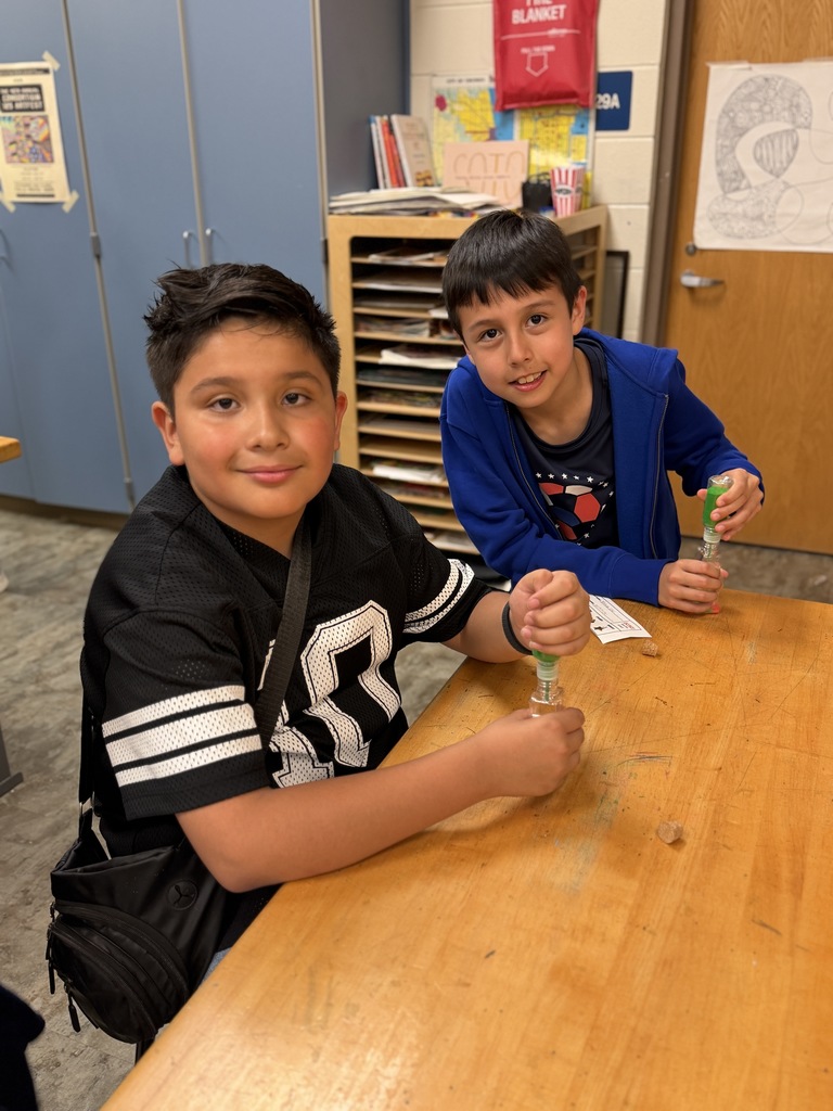 2 boys making sand art at a table.
