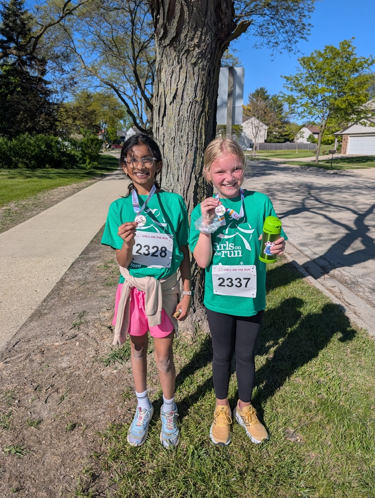 2 girls holding their medals. 