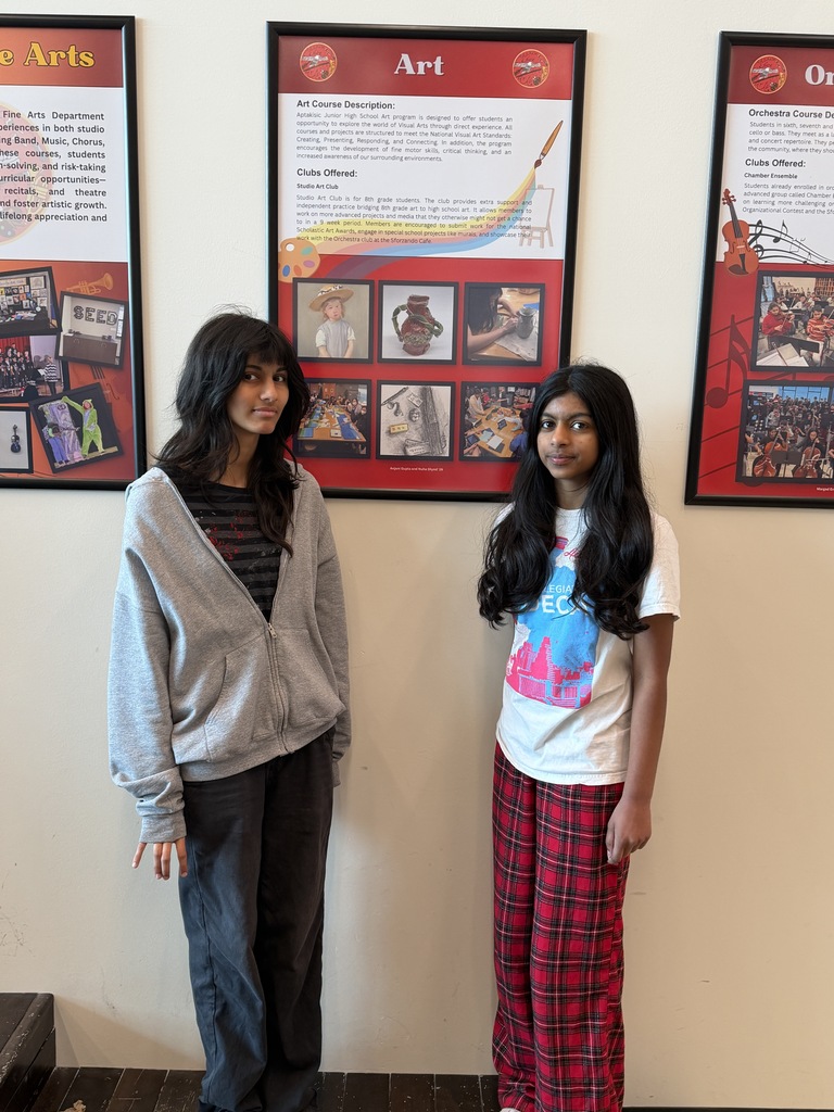 Two students standing by their art poster.