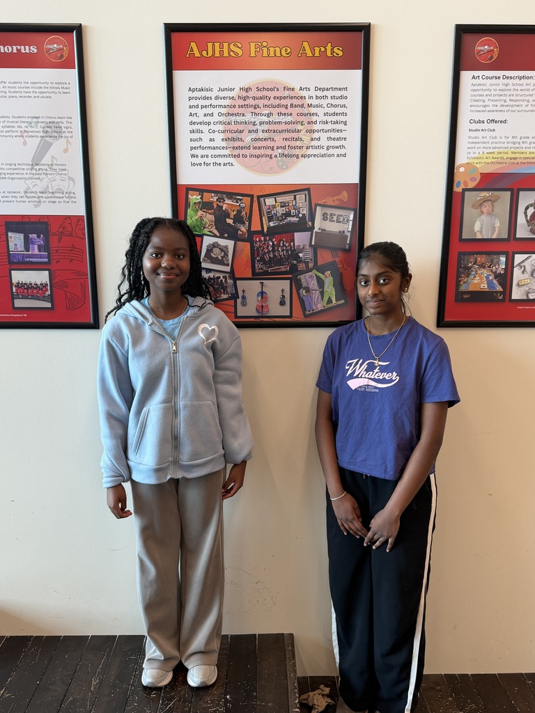 2 girls standing by their art poster.