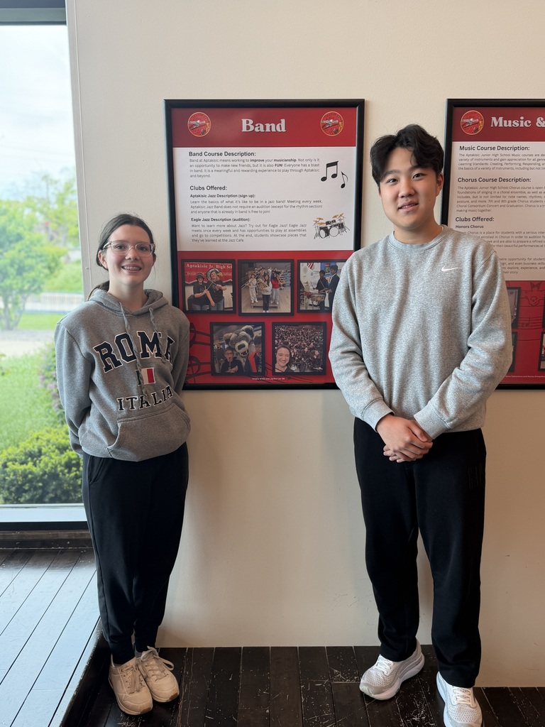 2 students standing by their art poster.