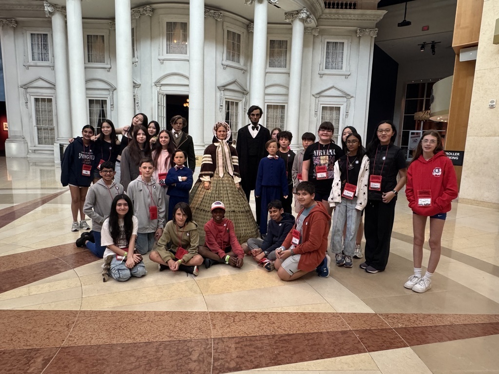 Students standing in front of characters. 