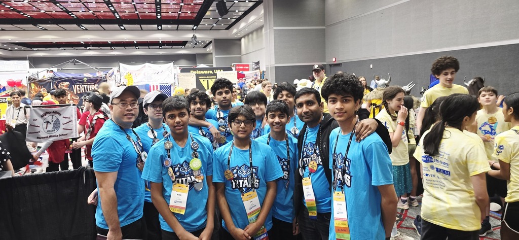 Titan team posting with Mr. Cho, wearing blue shirts.