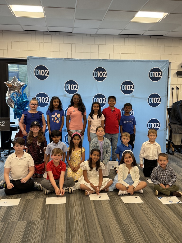 Students standing and posing against a backdrop. 