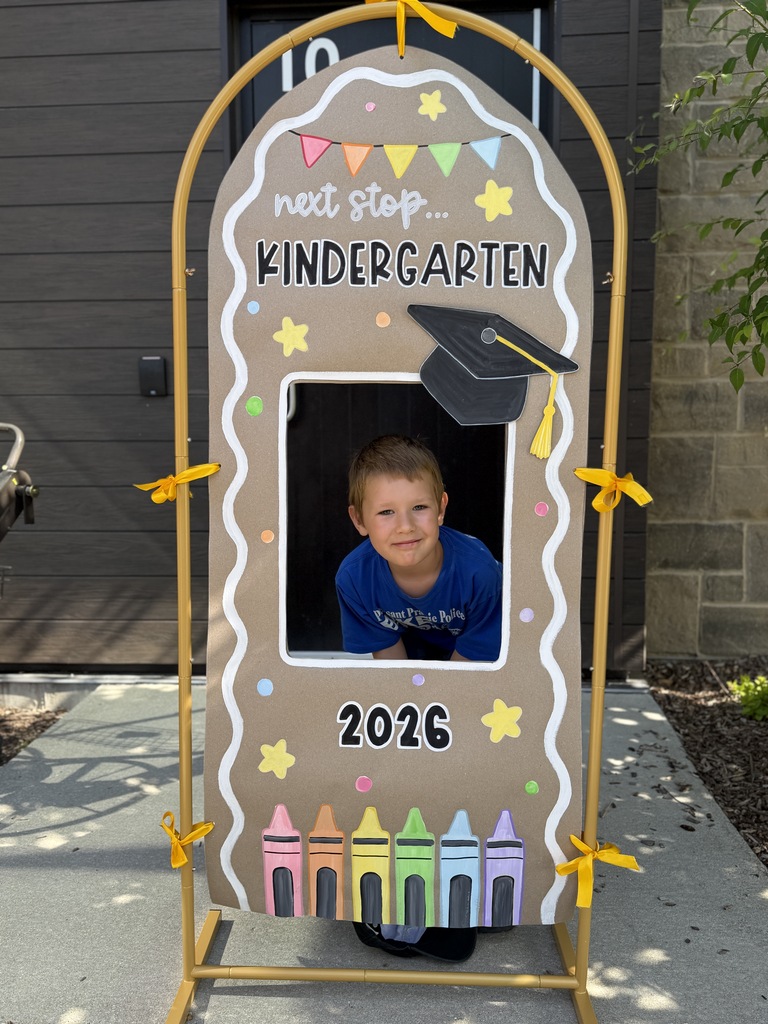 STudent in a "next stop, kindergarten" sign.