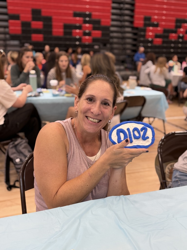 Teacher holding a D102 clay creation.