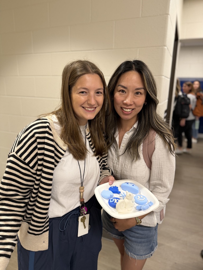 2 teachers holding a plate with clay creations.