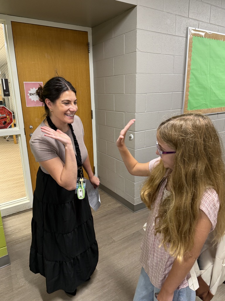 teacher giving a girl a high five.